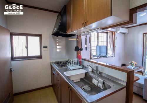 a small kitchen with a sink and a stove at GLOCE 半原 River Side House ｌリバービュー1軒貸切ｌ最大8名ｌワンちゃんOK in Managura