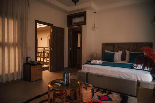 a bedroom with a large bed and a table at Riad Kenza in Marrakech