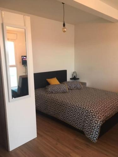 une chambre avec un lit et un miroir dans l'établissement Beau studio appart meublé à La Suze Dispo septembre 2025, à La Suze-sur-Sarthe