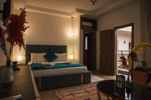 a bedroom with a bed with blue pillows at Riad Kenza in Marrakech