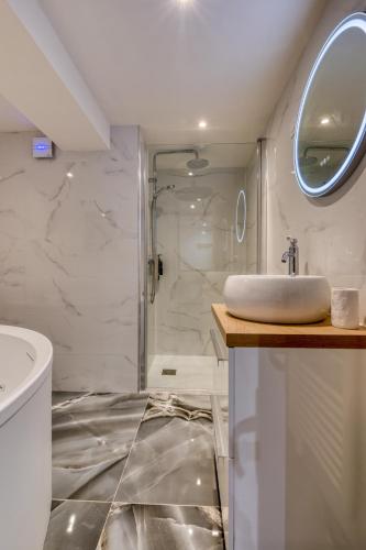 une salle de bain blanche avec un lavabo et une douche dans l'établissement App Balnéothérapie 5min du port, à Fécamp