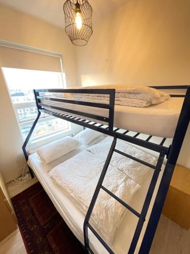a bunk bed in a room with a window at Modern and spacious 3 bedroom apartment in Kópavogur in Reykjavík