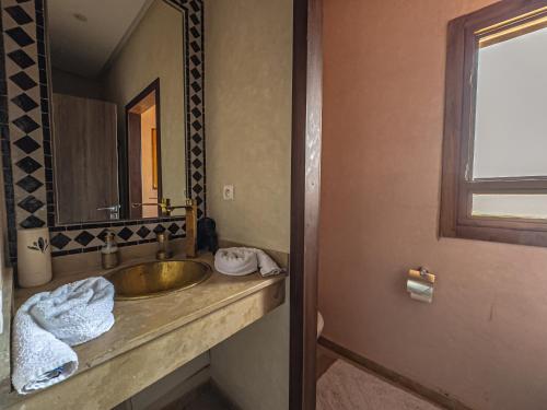 a bathroom with a sink and a mirror at Riad Kenza in Marrakech