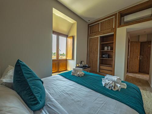 a bedroom with a large bed with blue sheets and pillows at Riad Kenza in Marrakech