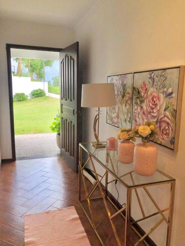 a room with a glass table with a lamp and flowers at Vivenda Flor in Ponta Delgada