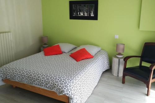 - une chambre avec un lit doté de 2 oreillers rouges et d'une chaise dans l'établissement Très joli T2 indépendant 250 m2 jardin privatif, à Saint-Malo