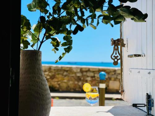 un vase posé sur une table avec un verre de vin dans l'établissement La Cachette de Camille - Vue Mer, à Sète