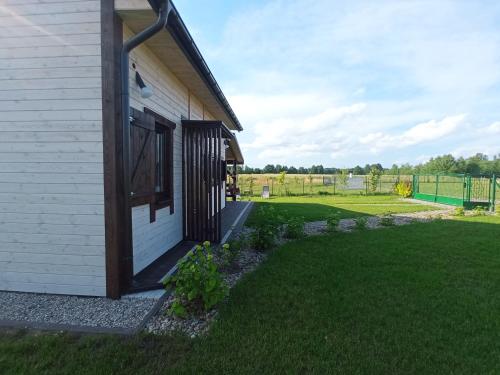 a front porch of a house with a grass yard at Domek Tomaszne in Uścimów
