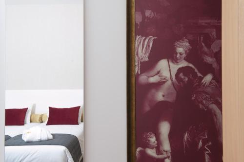 a painting of a man sitting on a bed at Hotel Parque Serra da Lousã in Miranda do Corvo