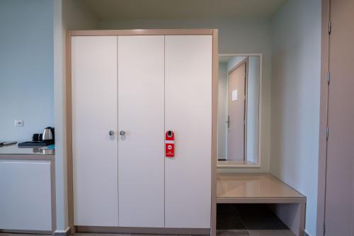 a white cabinet in a kitchen with a mirror at Franklin Rooms in Sarandë
