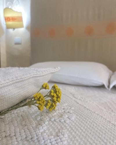 a bouquet of yellow flowers on a bed at Il Nuraghe del lago Coghinas in Oschiri