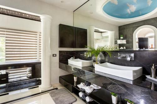 Un baño con dos lavabos y un espejo grande. en CASA YOLO - Luxury 4 BR Comfort, Elegance at the paradise in Playacar!, en Playa del Carmen