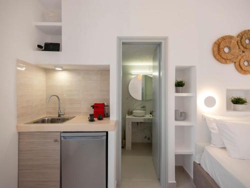 a small kitchen with a sink and a bed at M&M Parikia's Old Town Studio in Parikia