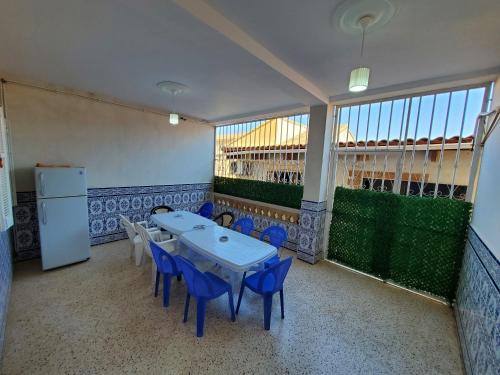 a room with a table and chairs and a refrigerator at Location vacance drissou in Aguemoun Taïda