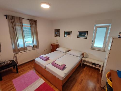 a bedroom with a large bed and two windows at Savski Gaj in Zagreb