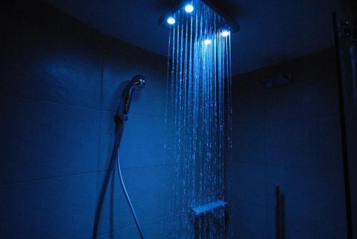La salle de bains est pourvue d'une douche avec des lumières bleues. dans l'établissement Chamonix Centre Holiday Sauna Apartment 2, à Chamonix-Mont-Blanc