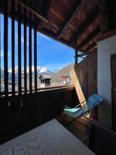 a chair on a balcony with a view of the mountains at Locanda Nona Giò in Fornesighe