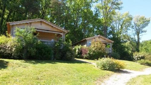 une maison dans une cour herbeuse avec une allée dans l'établissement L'Ecrin de nature, à La Bachellerie