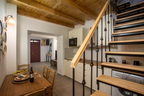 a kitchen and dining room with a wooden table and stairs at Alexandras Stone House in Rhodes Town