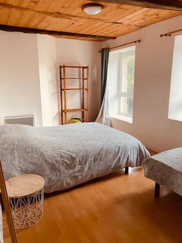 une chambre avec un lit, une chaise et une fenêtre dans l'établissement La verte Dinannaise, à Quévert