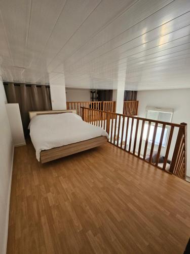ein Schlafzimmer mit einem Bett auf einem Holzboden in der Unterkunft Jolie appartement près de la plage in Berck-sur-Mer