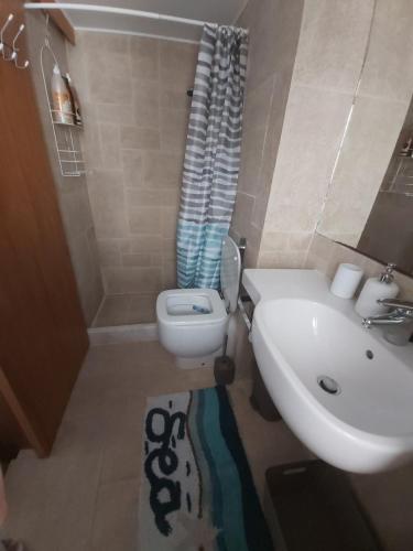 a bathroom with a sink and a toilet and a shower at 89 Steps Symi in Symi