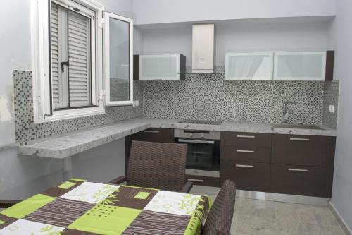 una cucina con tavolo, sedie e bancone di Villa Daniella studio with private pool a Nisakion