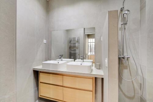 une salle de bain avec deux lavabos et une douche dans l'établissement Magnifique loft 6P proche Bastille, à Paris