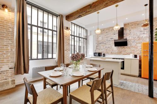 une cuisine et une salle à manger avec une table et des chaises dans l'établissement Magnifique loft 6P proche Bastille, à Paris