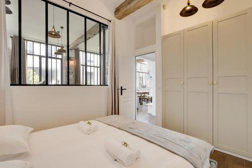 une chambre avec un lit et une grande fenêtre dans l'établissement Magnifique loft 6P proche Bastille, à Paris