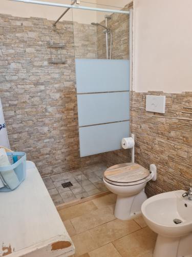 a bathroom with a shower and a toilet and a sink at casa 44gatti in Martina Franca