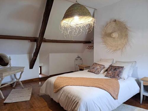 une chambre avec un lit et un lustre dans l'établissement Gîte Chaumière de Floranges 6 personnes Morbihan, à La Chapelle-Neuve
