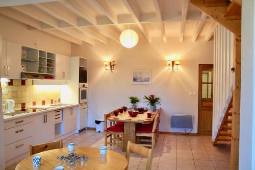 une cuisine et une salle à manger avec une table et des chaises dans l'établissement Résidence La Prairie, à Villard-de-Lans