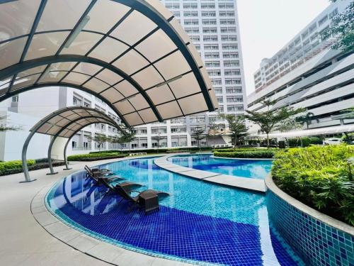 a large swimming pool in a city with buildings at Sanguine Staycation in Manila