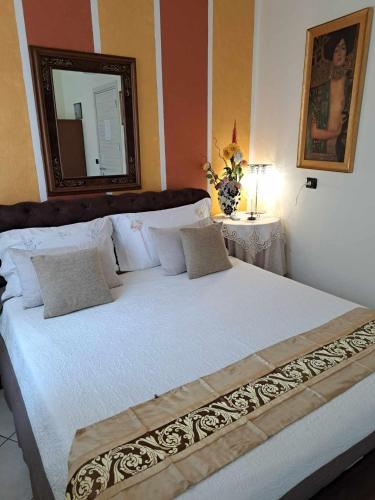a bedroom with a large white bed with a mirror at B&B Gardasee in Castelnuovo del Garda