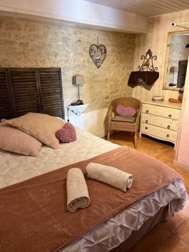 a bedroom with a large bed with two towels on it at La Naomath - Maison d'hôtes, Hébergement insolite & Gîte in Bayeux