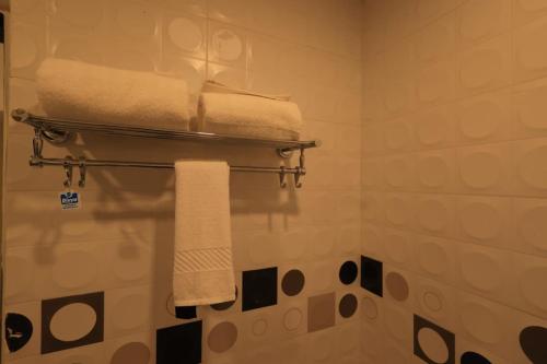 a bathroom with white towels on a towel rack at The Hotel SAAJ-Premium in Bhubaneshwar