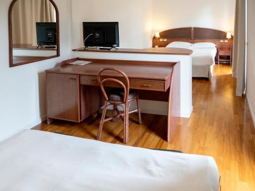 a hotel room with a desk and a bed at Hotel Altamira in Orsogna