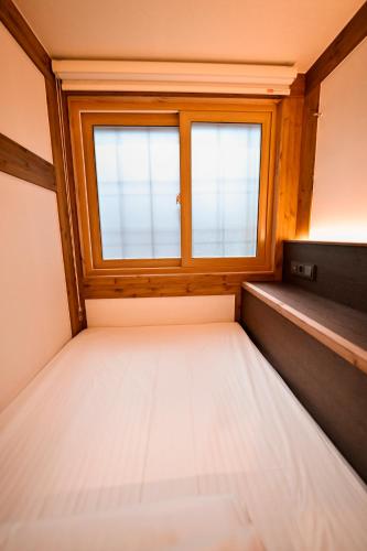 an empty room with a window and a mattress at Hanok Hotel DAAM Seoul in Seoul