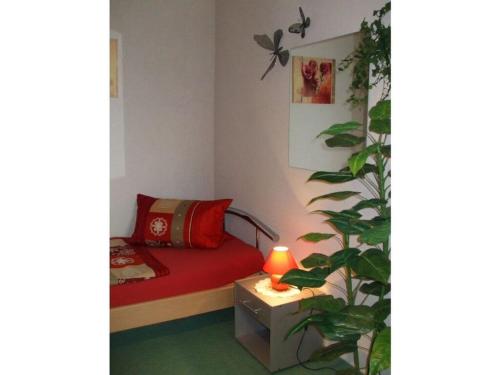 a bedroom with a red bed and a plant at Evening sun Comfortable holiday residence in Schönberg