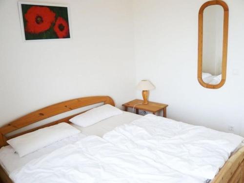 een slaapkamer met een wit bed en een rood bloemschilderij aan de muur bij House Thor - Huus Asgard in Nieby