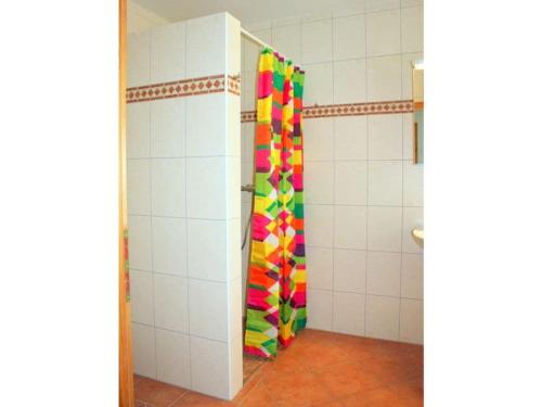 a shower stall with a colorful curtain in a bathroom at Morning sun Comfortable holiday residence in Westerstede