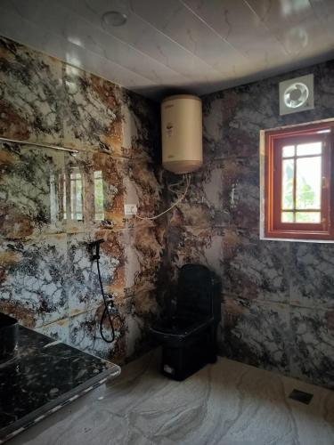 a dirty room with a stove and a window at The Bilt farmhouse in Srinagar