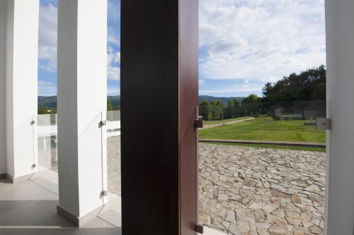 an open door with a view of a field at Hotel Parque Serra da Lousã in Miranda do Corvo