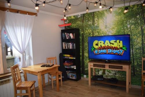 a living room with a tv and a table with chairs at Panorama Premium in Kościelisko