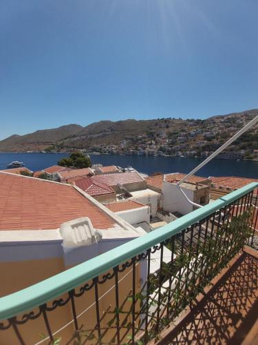 a balcony with a view of a city and the water at 89 Steps Symi in Symi