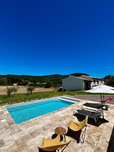 une piscine avec des chaises et un parasol dans l'établissement Villa Loan, à Mollans-sur-Ouvèze
