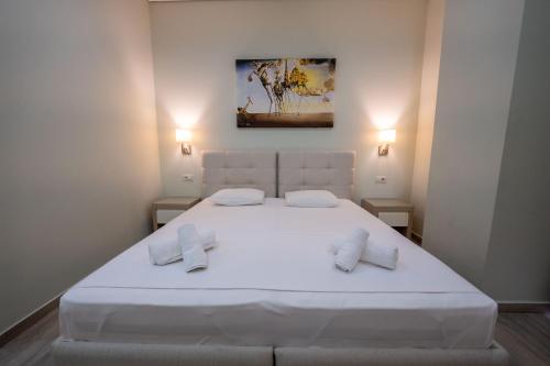 a bedroom with a large white bed with two pillows at Franklin Rooms in Sarandë