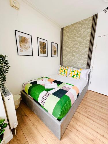 a bedroom with a bed with a colorful blanket on it at Stylish Private Room opposite Queen Elizabeth Hospital - Harborne Birmingham RA in Birmingham