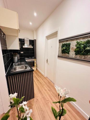 a kitchen with a sink and a counter top at Stylish Private Room opposite Queen Elizabeth Hospital - Harborne Birmingham RA in Birmingham